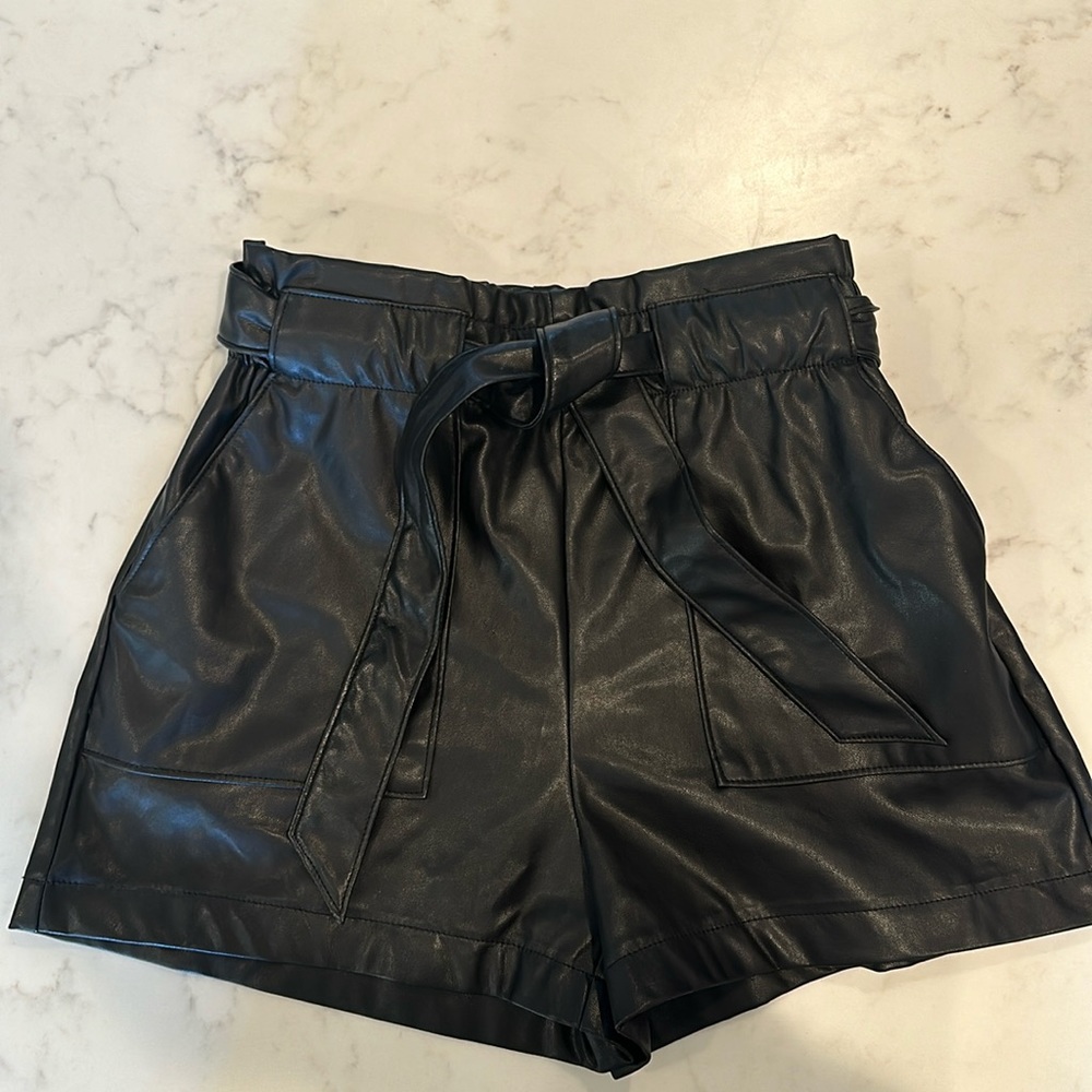 Size small faux leather shorts with pockets. Elastic waist with tie.